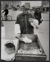 [Man eating from box of herring, Jyväskylä, Finland]