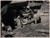 [Men sitting on ground]