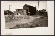 [Abandoned building with woman out front]