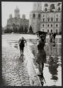 [Girl holding book over head during rainstorm with Saint Basil's Cathedral in background, Moscow]