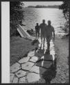 [Nude men walking away from dock]