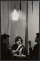 [Woman dining with two men, Moscow]