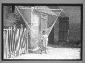 Little Girl Standing in Front of Fishing Nets