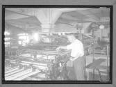 [Man Inspecting Press]