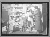 [Two Women Help Children Dress]