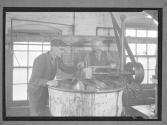 [Two Men Testing Vat Temperature]