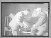 [Two Men Upholstering]