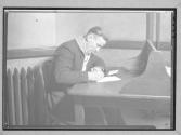 [Man Writing Letter at Desk]