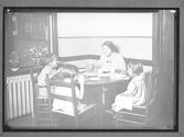 [Woman, Three Children at a Meal]