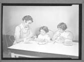 [Girl, Two Children at a Meal]