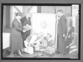 [Group preparing photographs for exhibit]