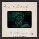 [Mimi Muray reading a newspaper, West Hampton, New York (travel slide)]