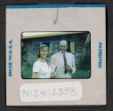 [Man and woman standing outside (travel slide)]