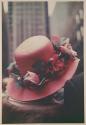 [Woman wearing pink hat with silk roses]