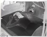 [Woman lying in bed under lamp]