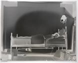 [Woman lying in bed in studio]