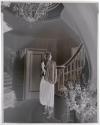 [Woman standing on staircase]