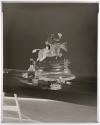 [Whiskey bottle and glass, figurine of a man riding a horse, and fishing equipment (Hunter)]