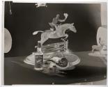 [Whiskey bottle, glass, and a figurine of a man riding a horse (Hunter)]