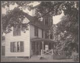 [House with woman on porch]