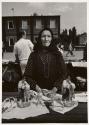 An old lady from Ukraine (Lvov) is selling at open sky market in Ostrava, glass sculptures of lovers