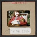 [Peggy Muray holding a dog (travel slide)]