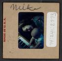 [Mimi Muray playing a piano (travel slide)]