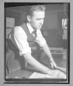 [Man Cutting Cloth by Hand]