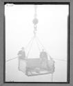 [Two men in derrick lift]