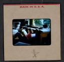 [Peggy Muray reading a newspaper (travel slide)]