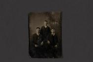[Three men posing in studio]