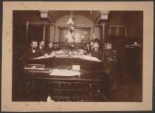 [Group of men at table]