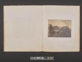 [Buildings and church spire behind trees]