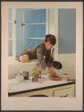 [Boy climbing in kitchen window]