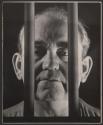[Man behind bars]