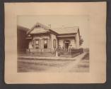[Family in front of house with dogs and horse \ Family in front of house in town]