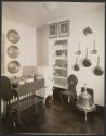 Interior view of kitchen with chair, rolling cart and hanging pots