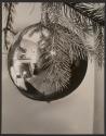Modernist study of fireplace reflected in Christmas ornament