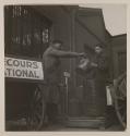 Workers passing metal jug