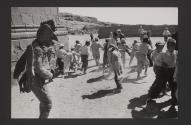 Person in rooster costume with children in the background
