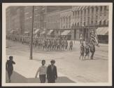 [Snapshot of soliders holding American flag in parade]
