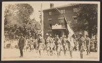 [Snapshot of soldiers holding American flag in parade]