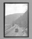 [auto driving by river, railroad track]