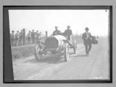 [auto racers passing spectators]
