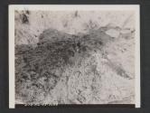 [Remnants of a mine case lying in its crater after demolition performed during regimantal maneuvers in England. The white part on the mine is the TNT charge. 7th Engr Regt, 5th Inf Div., Blackpool Sands, Devon, England.]