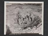[Soldiers in crater left by beach mine which was exploded during mine demolition exercises in England. The men are examining pieces of shrapnel from the mine. 7th Engr Regt, 5th Inf Div, Blackpool Sands, Devon, England.]