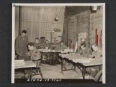[Staff of a divisional signal school in the United Kingdom at work in their office constructed in part from old packing box lumber. Left to right: CPL Dana Mansfield, Athens, OHIO, clerk; PVT Fred Oswald, Chicago, ILL., Draftsman; WO (JG) Floyd Thompson, Atlanta, GA., S-3; LT Geo. T. Allison, Jr., Ardmore, PA., School Commander; T/SGT Glendon R. Frank, Marshfield, WIS., Chief Instructor; and S/SGT Milton L. Jackson, Corsicana, Texas. 5th Inf Div., Newcastle, County Down, No. Ireland.]