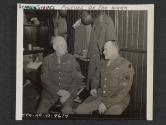 [T/4 Domenik Takmauh, Boston, MASS., talks over old times with M/SGT Theron C. Bollinger, Battle Creek, MICH. Both men have had nearly 27 years of Army service…and in the same outfits, including the World War I.  5th Inf Div., Newcastle, County Down, No. Ireland.]