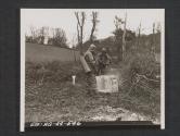 [Gas school in Northern Ireland. While dressed in impregnated, impervious clothing. Men of a decontamination squad spray a simulated building with decontamination liquid. 5th Inf Div, Seaforde, Co. Down. No. Ire.]