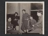 [Miss Marjorie Avery, Representing the Detroit Free Press, interviews soldiers from Michigan who belong to an infantry unit in [crossed out: Northern Ireland replaced with: Stet] left to right: T/5 Leo E. Creenwood, Escanaba; Miss Avery: T/4 Michael Deron, Detroit; T/4 Richard Muller, Ferndale; and SGT Francis Nadeau, Marquette. 5th Inf Div, Bryansford, County Down, Northern Ireland.]